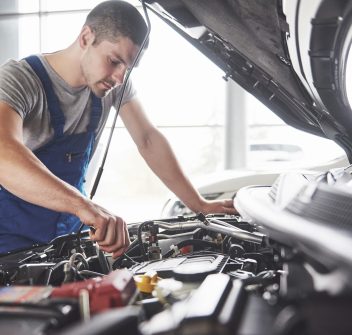 Auto mechanic working in garage. Repair service.